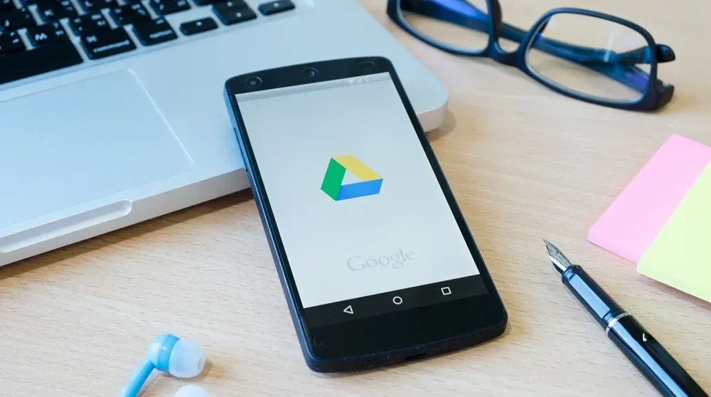 Marketing professional reviewing AI-generated Google Ads copy results on laptop in modern office