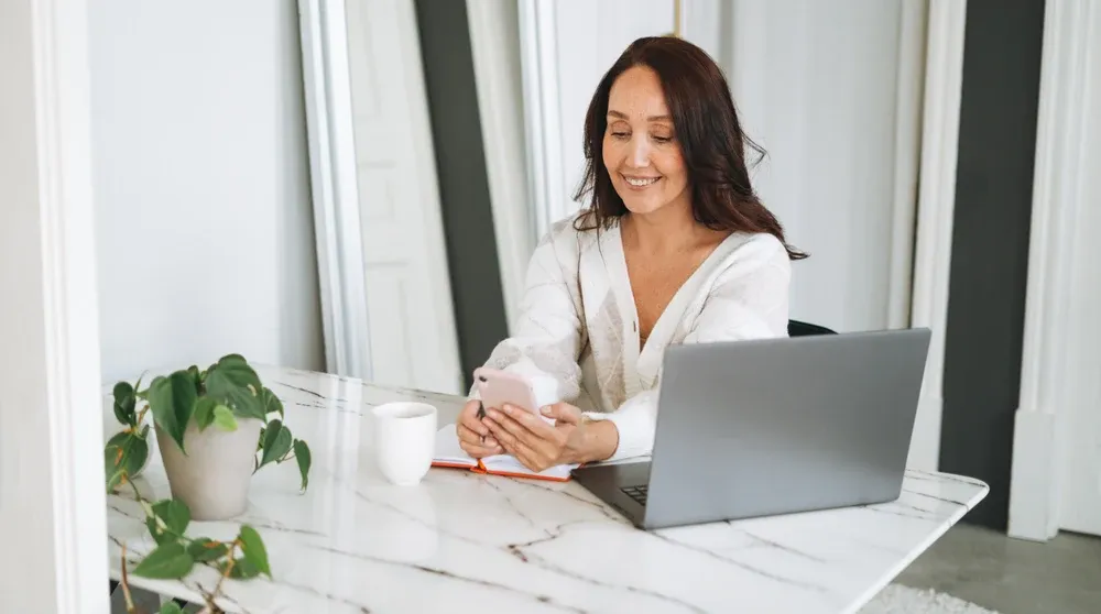 Business owner working on a laptop at a bright desk representing how to do a local seo audit for on-page signals