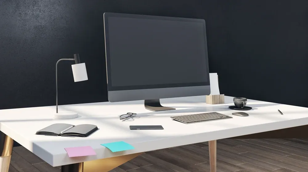 Clean modern office desk with monitor keyboard and lamp representing a professional google ad copy tool workflow
