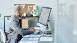 Franchise business manager reviewing multi-location local SEO performance dashboard on laptop