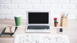 Clean desk with laptop, cactus and notebooks representing how to write Google Ads copy