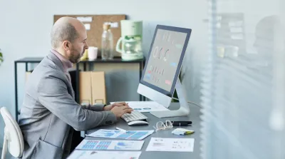 Franchise business manager reviewing multi-location local SEO performance dashboard on laptop