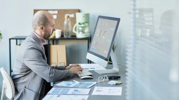 Franchise business manager reviewing multi-location local SEO performance dashboard on laptop