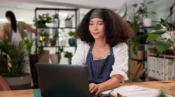 Small business owner working on laptop reviewing local SEO strategy